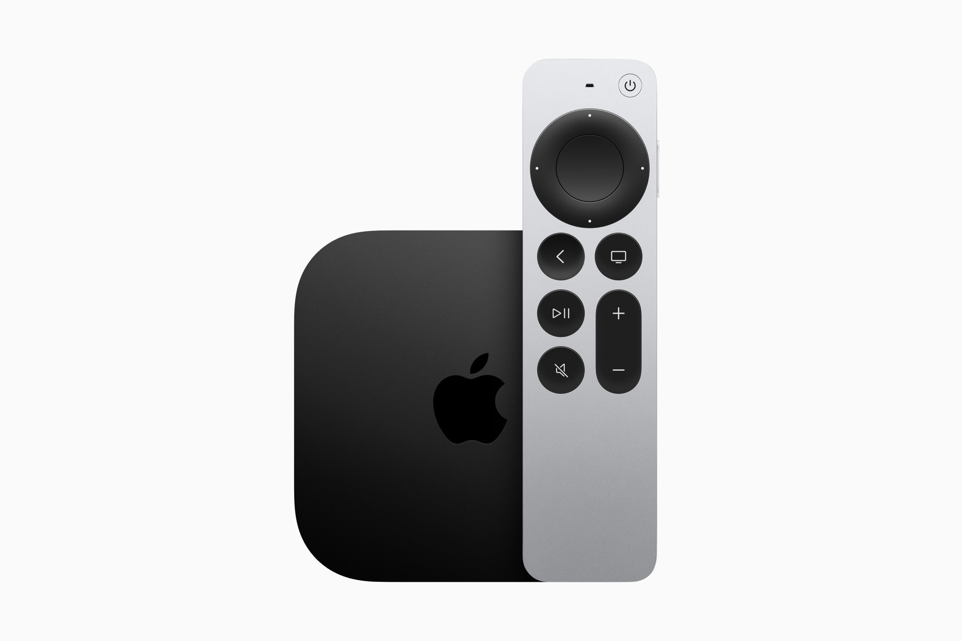 A black Apple T.V. with a silver remote next to it
